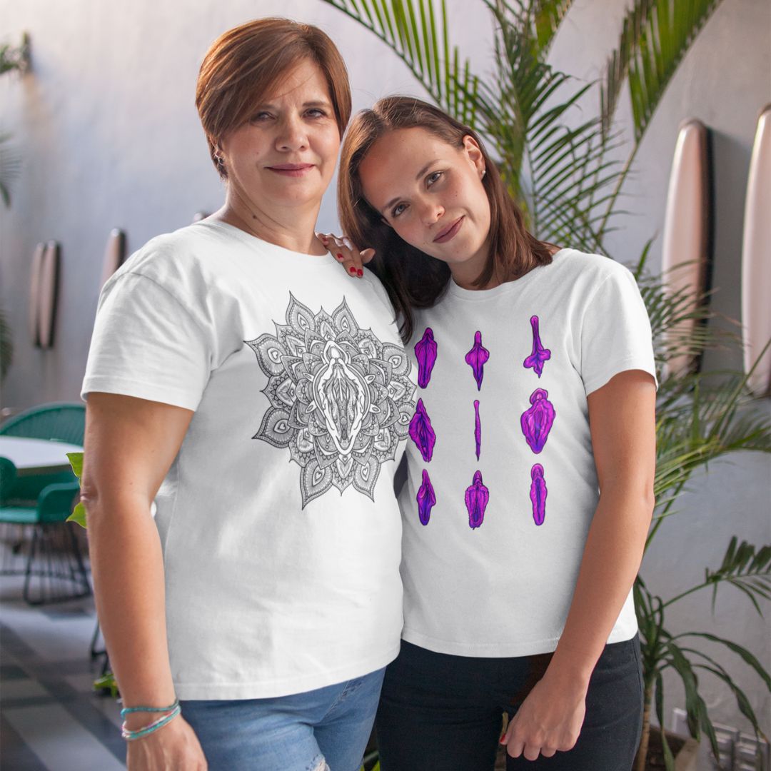 A photo of two people wearing vulva shirts and leaning on one another while smiling with warm confidence.