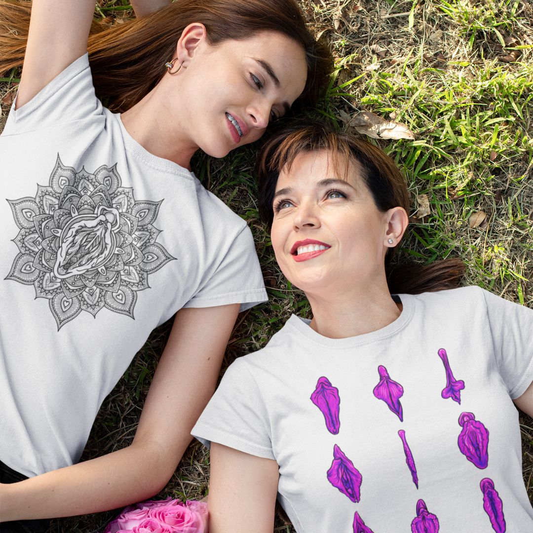 A photo of two people wearing vulva shirts and laying in the grass together.